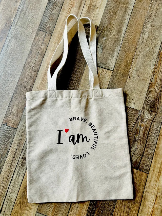 Become tote bag reading 'I am brave, beautiful, loved'